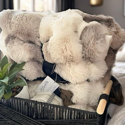 a basket filled with blankets and a plant
