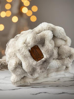 a white stuffed animal with a tag on it