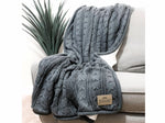 A gray knitted throw blanket is draped over the back of a gray sofa, with a small label on the blanket.