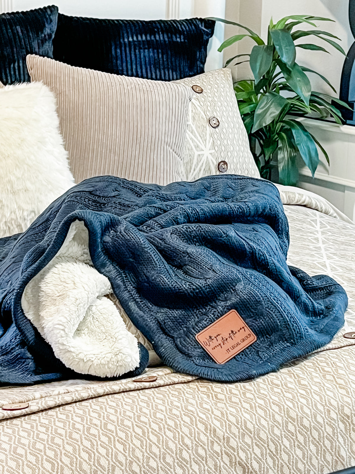 a bed with a blanket and pillows on top of it