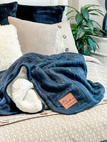 a bed with a blanket and pillows on top of it