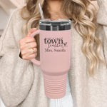 a woman holding a pink travel mug